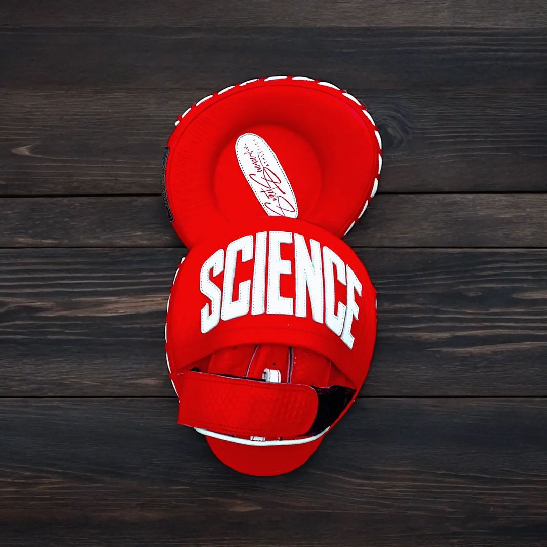 Red boxing glove with 'SCIENCE' text on a wooden background