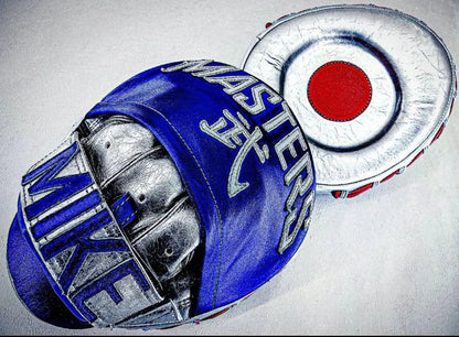 Personalised Boxing Gloves rest on custom embroidered focus pads with a red target circle, all displayed on a white surface—perfect as a Personalized Gift For Boxer or unique Sports Charm.